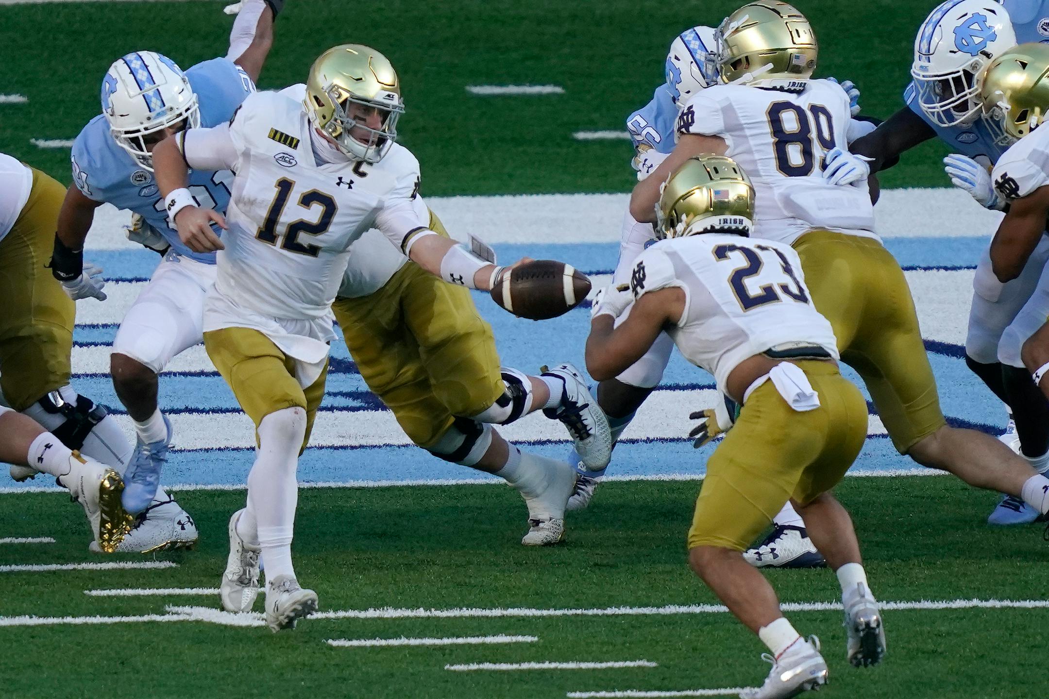 Notre Dame quarterback Ian Book (12) hands off to running back Kyren Williams (23) during the first half