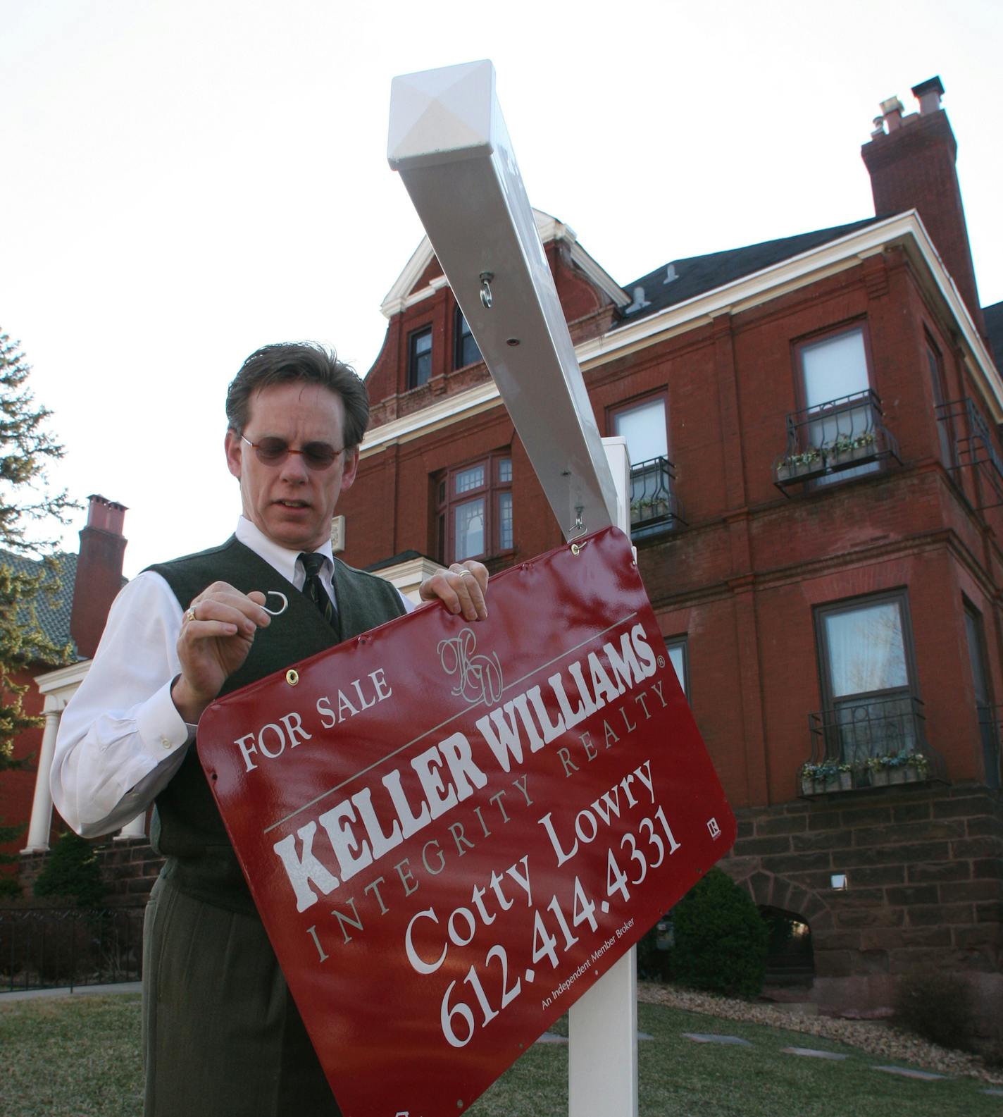 Cotty Lowry hangs a Keller Williams sign iin front of an old mansion on Ridgewood Av.
GENERAL INFORMATION: Duane Braley/Star Tribune--Minneapolis, Mn., Fri., Apr. 8, 2005--Keller Williams Realty is expanding and attractinghigh volume agents such as Cotty Lowry.