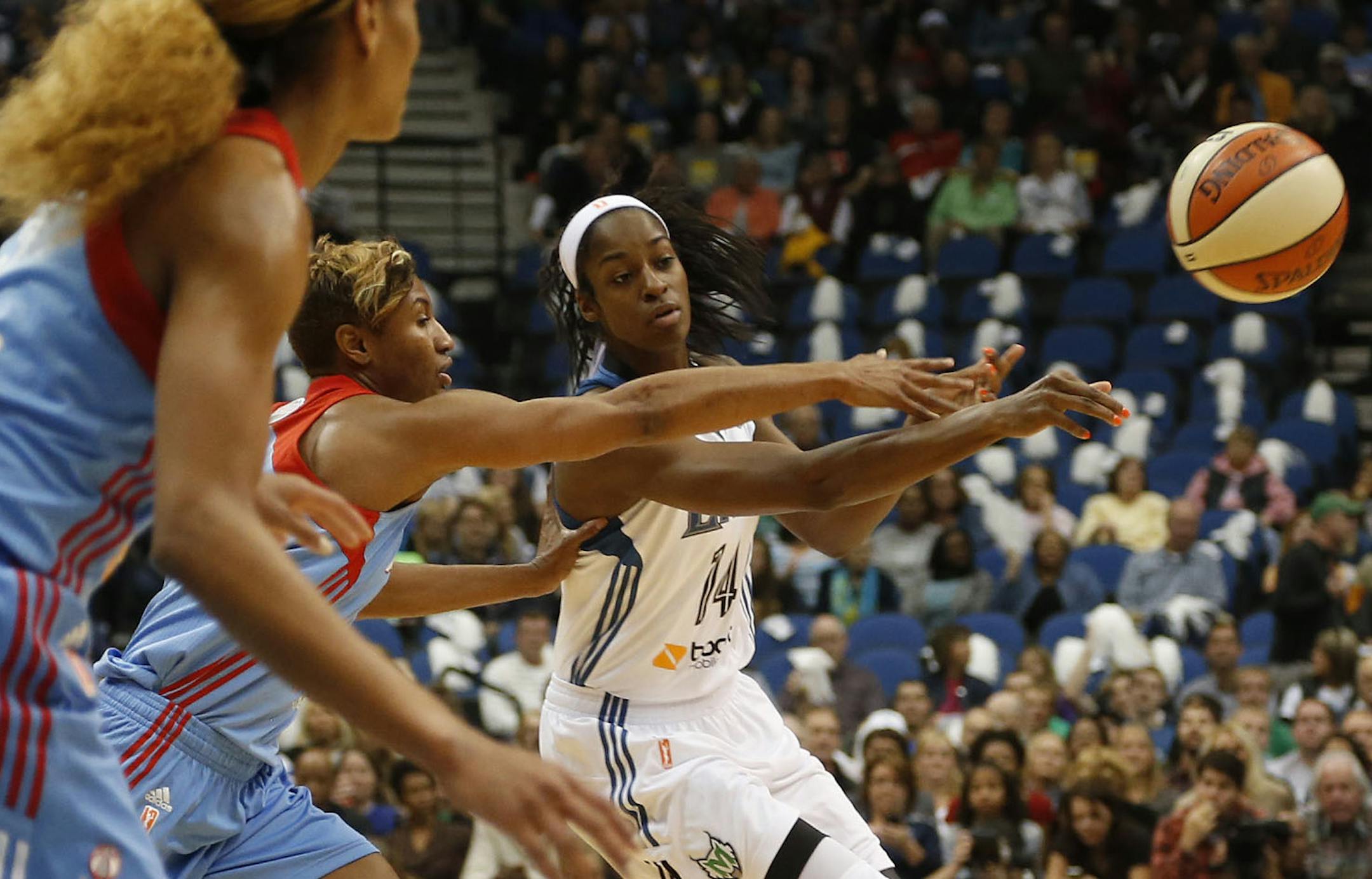 Devereaux Peters passed the ball to a teammate with the Dream's Angel McCoughtry defending during the first quarter of the WNBA Finals at Target Center in Minneapolis, Sunday, October 6, 2013