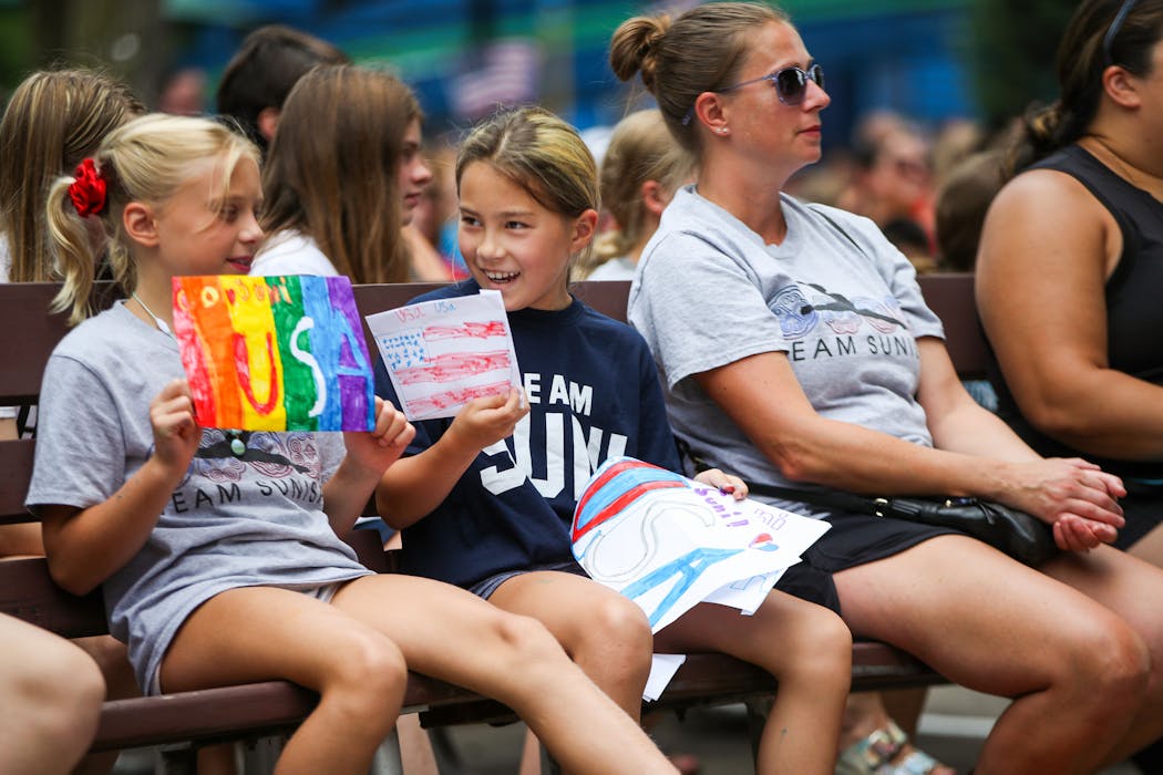 Emilia Zupancich, 9, left, and Lucy Walen, 8, center, listen to Suni Lee speak over a Zoom call in during a sendoff event for Team USA gymnasts at Leinie Lodge Bandshell on July 10 in Falcon Heights. Minnesota is sending three gymnasts to the Summer Olympics. Both girls are gymnasts who train out of Midwest Gymnastics, the same as Lee.