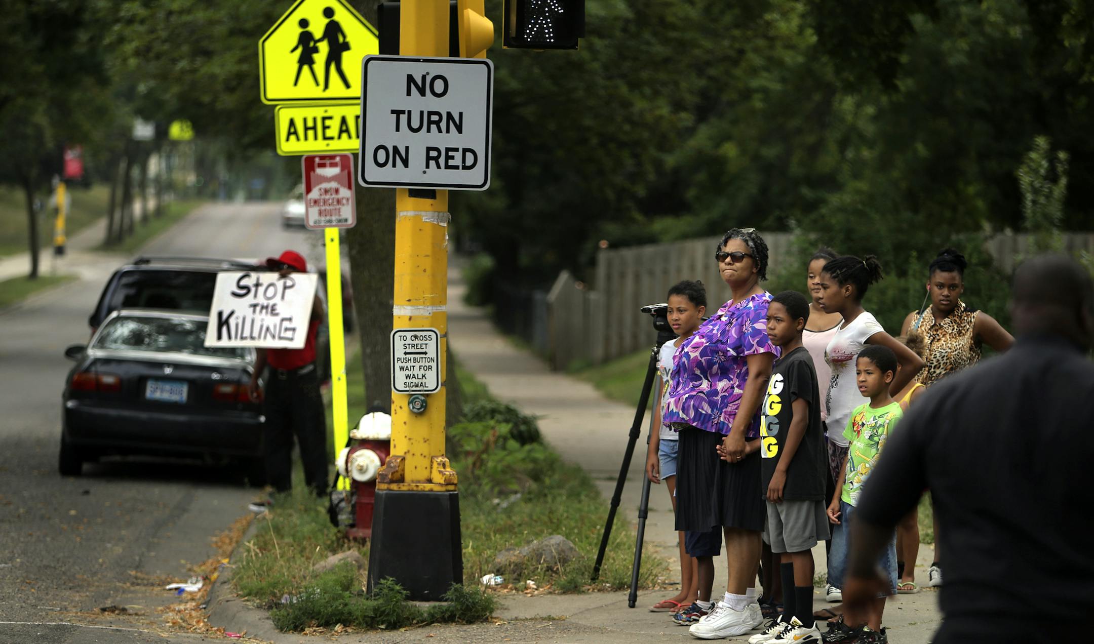 Tracy Farris, of North Minneapolis, escorts her children, grand children and nieces and nephews across Lyndale Ave. N. at 29th, in front of violence protestor Dwight Young Wednesday, Aug. 21, 2013, in Minneapolis, MN. Farris said there were two shootings recently in her neighborhood and "it's just gotten out of hand."](DAVID JOLES/STARTRIBUNE) djoles@startribune.com The gunfire didn't kill anybody this time, but the shooting of a 14-month-old baby and a pregnant woman Tuesday brought fresh atten