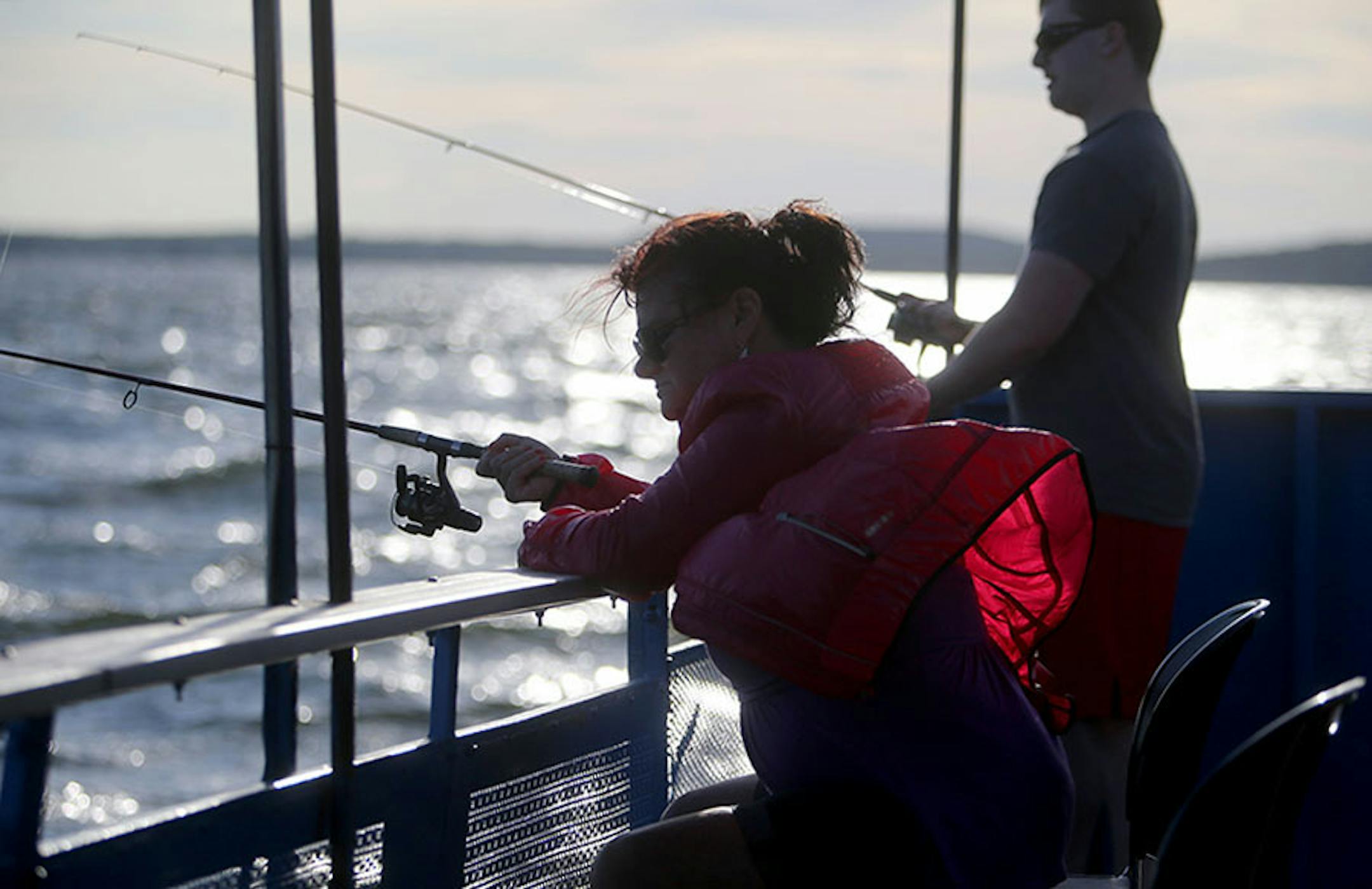 Margo Hill, front, and her son Carl fish for walleyes on the Twin Pines Resort boat near sunset Wednesday, July 29, 2015, during an evening excursion on Lake Mille Lacs.