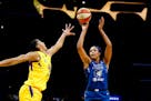WNBA Rookie of the Year Napheesa Collier, right, shoots while defended by Los Angeles Sparks' Candace Parker during the first half of a game last seas