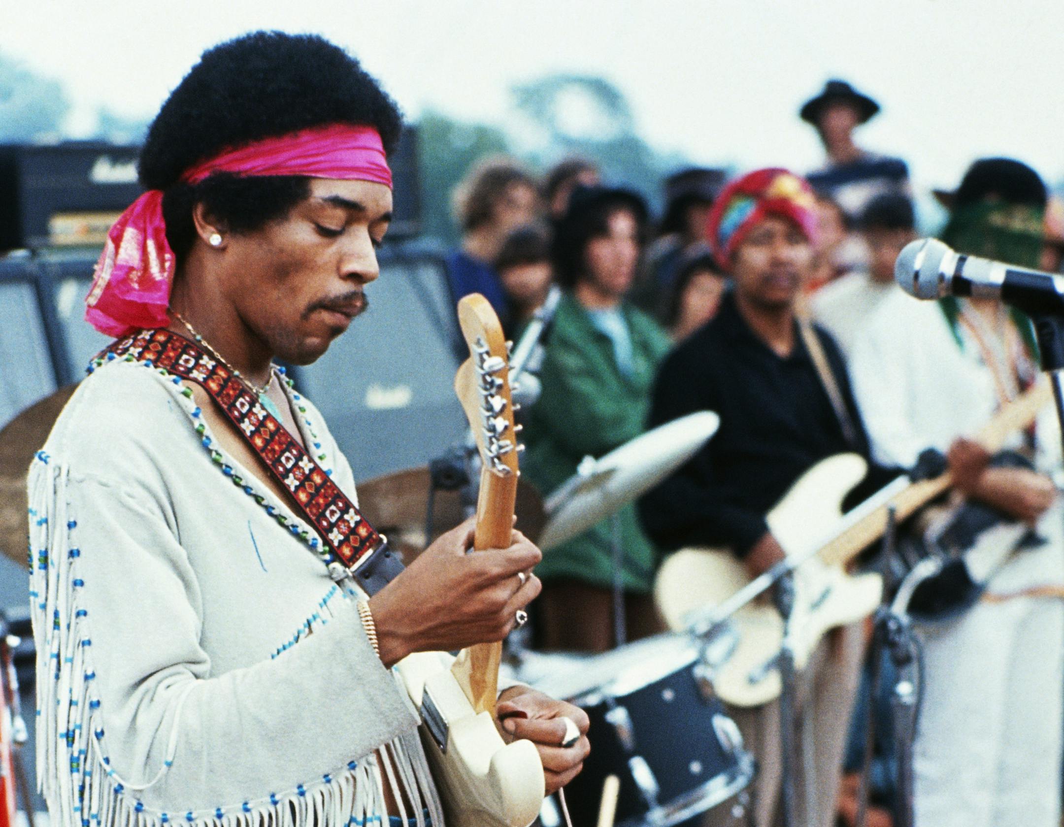 18 Aug 1969, Near Bethel, New York, USA --- Jimi Hendrix playing his guitar during his set at the Woodstock Music and Art Fair. Playing with Jimi Hendrix is Billy Cox (wearing a turban). --- Image by Â© Henry Diltz/CORBIS ORG XMIT: MIN2013030810155612