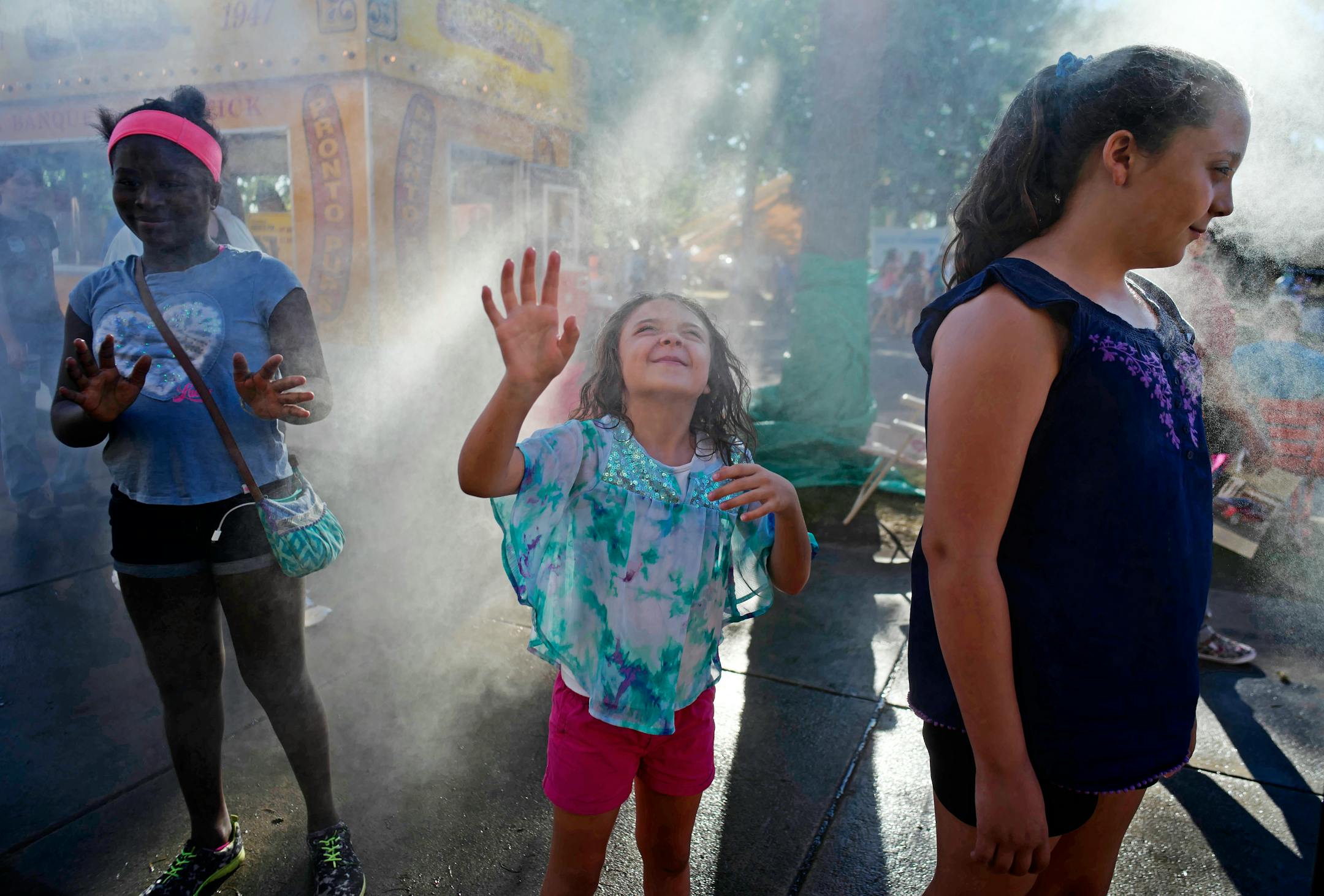 Sisters Sophia, 6, and Danielle Gubash, 10, cooled off in the misters near the Fine Arts building at the State Fair.