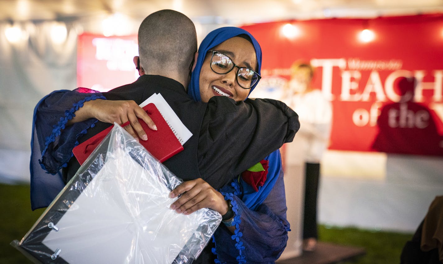 Qorsho Hassan, a fifth grade teacher at Gideon Pond Elementary School in the Burnsville-Eagan-Savage School District, is named Education Minnesota's 2020 Teacher of the Year, gets a hug from 2018 Teacher of the Year Kelly D. Holstine during a ceremony at the State Capitol. ] LEILA NAVIDI • leila.navidi@startribune.com BACKGROUND INFORMATION: Education Minnesota's Teacher of the Year ceremony outside the State Capitol in St. Paul on Thursday, August 6, 2020.