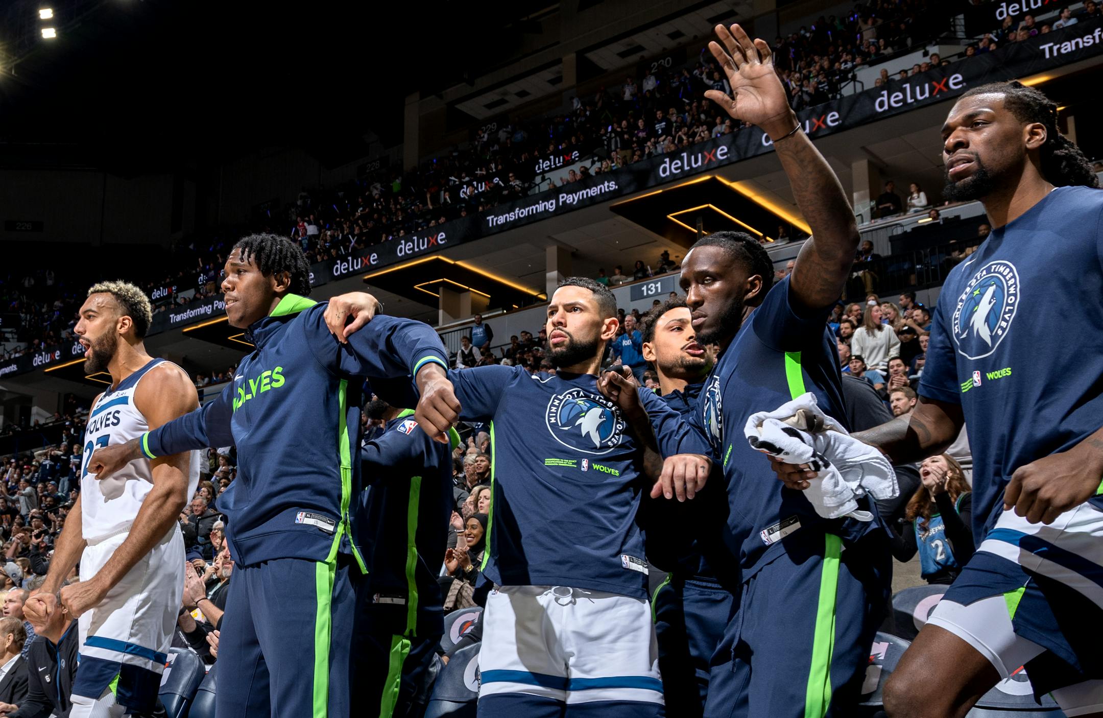 Wolves players on the bench react after a dunk by Jaden McDaniels in the first quarter Wednesday during the season opener at Target Center