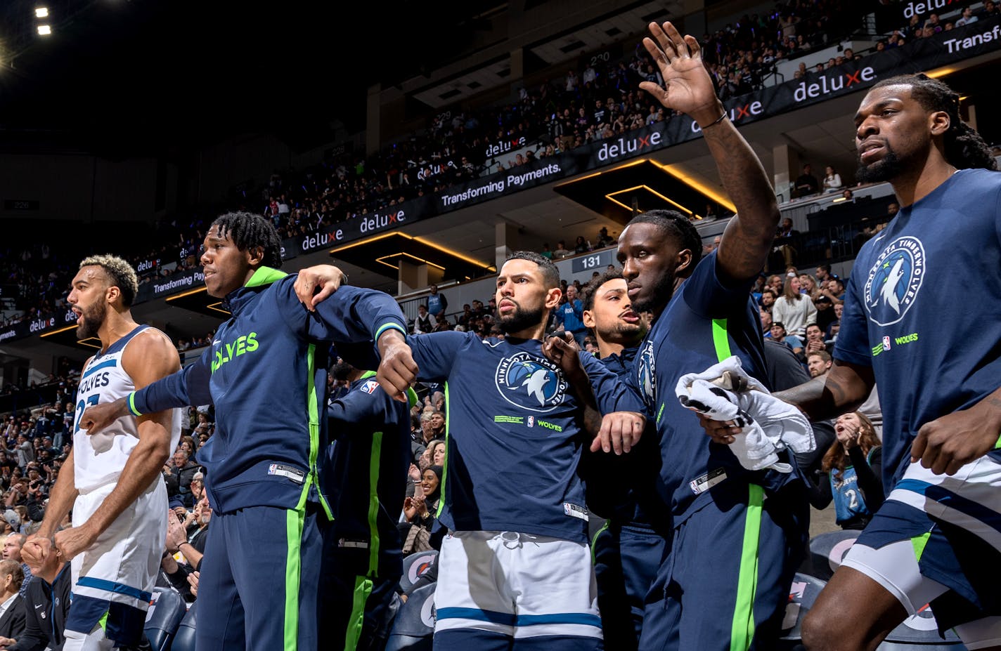 Wolves players on the bench react after a dunk by Jaden McDaniels in the first quarter Wednesday during the season opener at Target Center