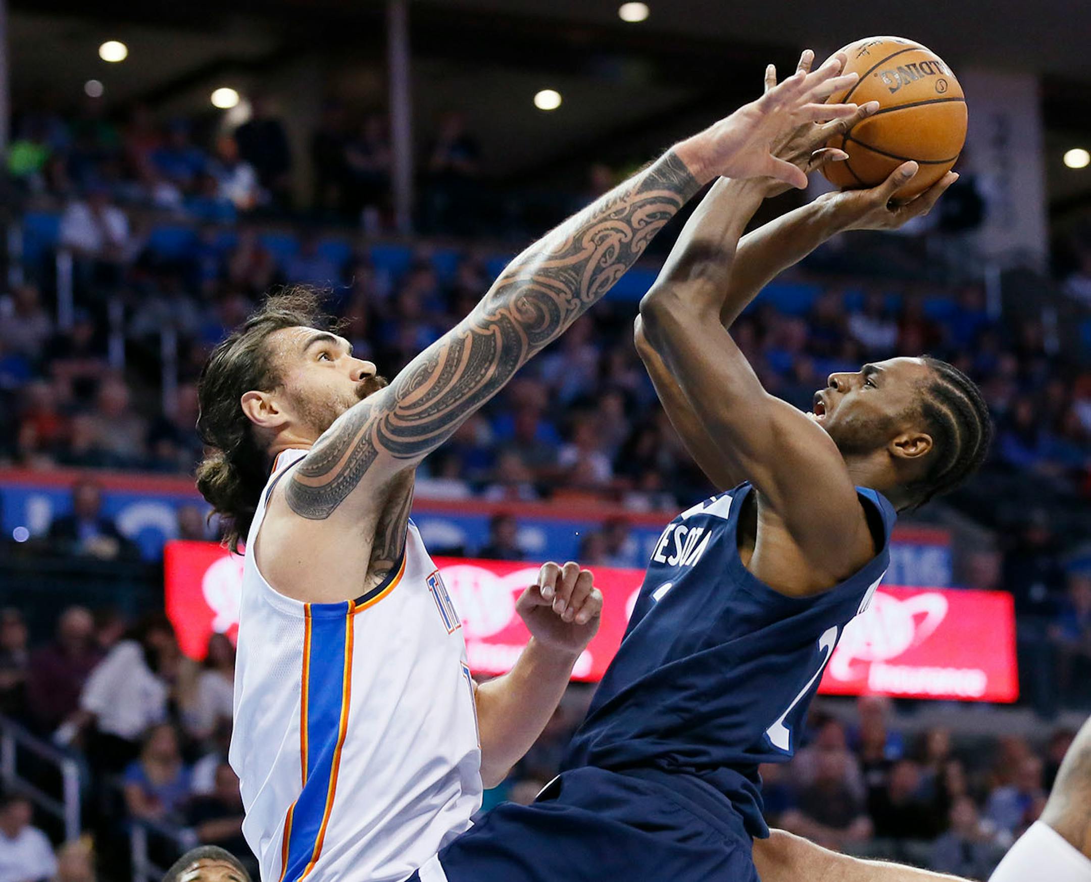 Oklahoma City Thunder center Steven Adams, left, blocks a shot by Minnesota Timberwolves guard Andrew Wiggins, right, in the first quarter of an NBA basketball game in Oklahoma City, Sunday, Oct. 22, 2017.
