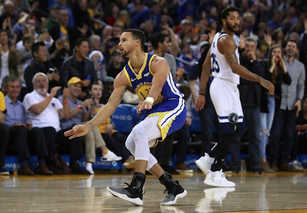 Stephen Curry celebrates a score as theTimberwolves' Derrick Rose looked on in the second half