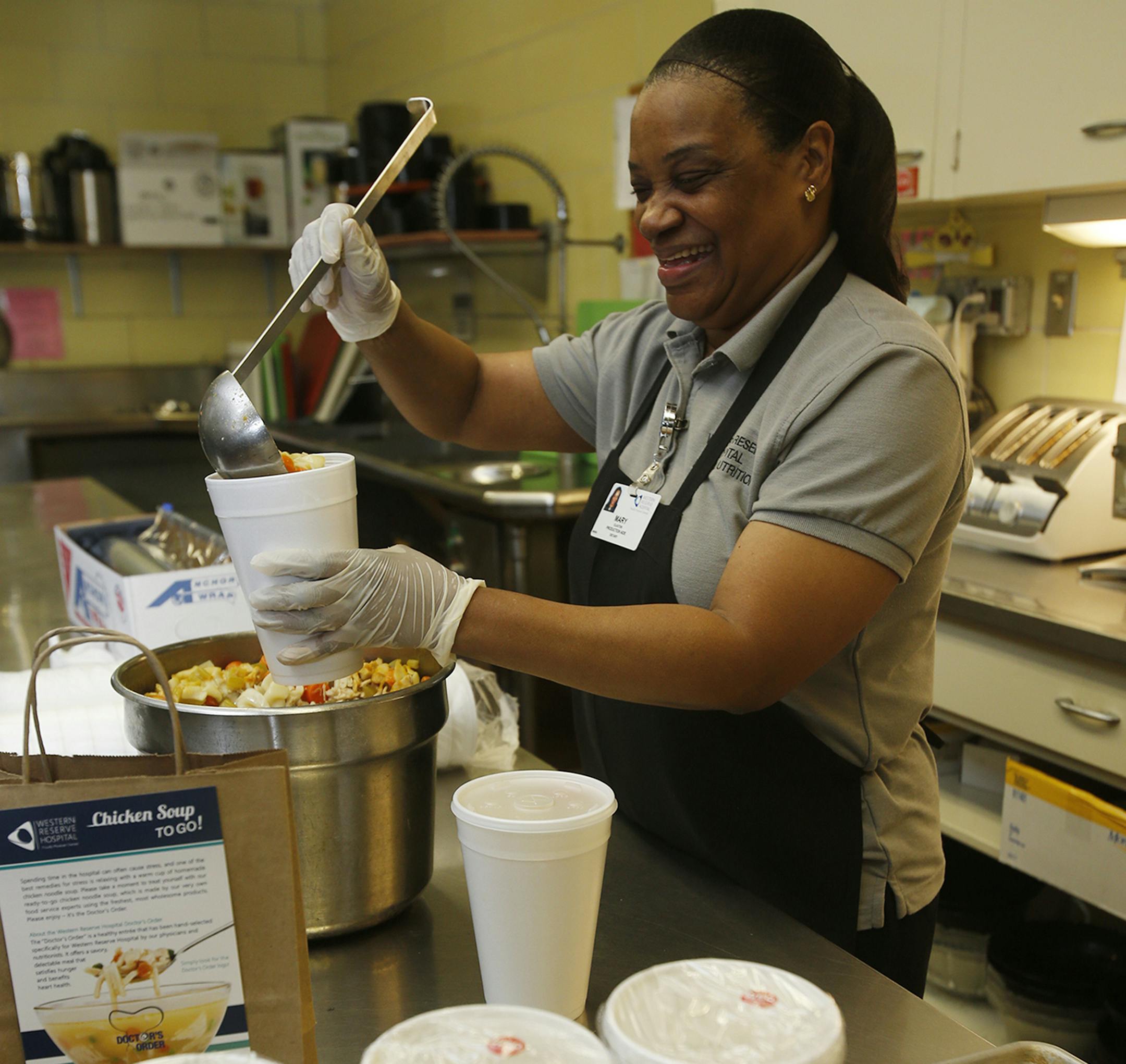 Mary Claxton, production assistant at Western Reserve Hospital, ladles out quart containers of chicken soup in the hospital's kitchen on Tuesday, March 10, 2015, in Cuyahoga Falls, Ohio. The soup is part of the hospital's new Soup to Go program for patients who undergo outpatient surgery. (Karen Schiely/Akron Beacon Journal/TNS) ORG XMIT: 1165117