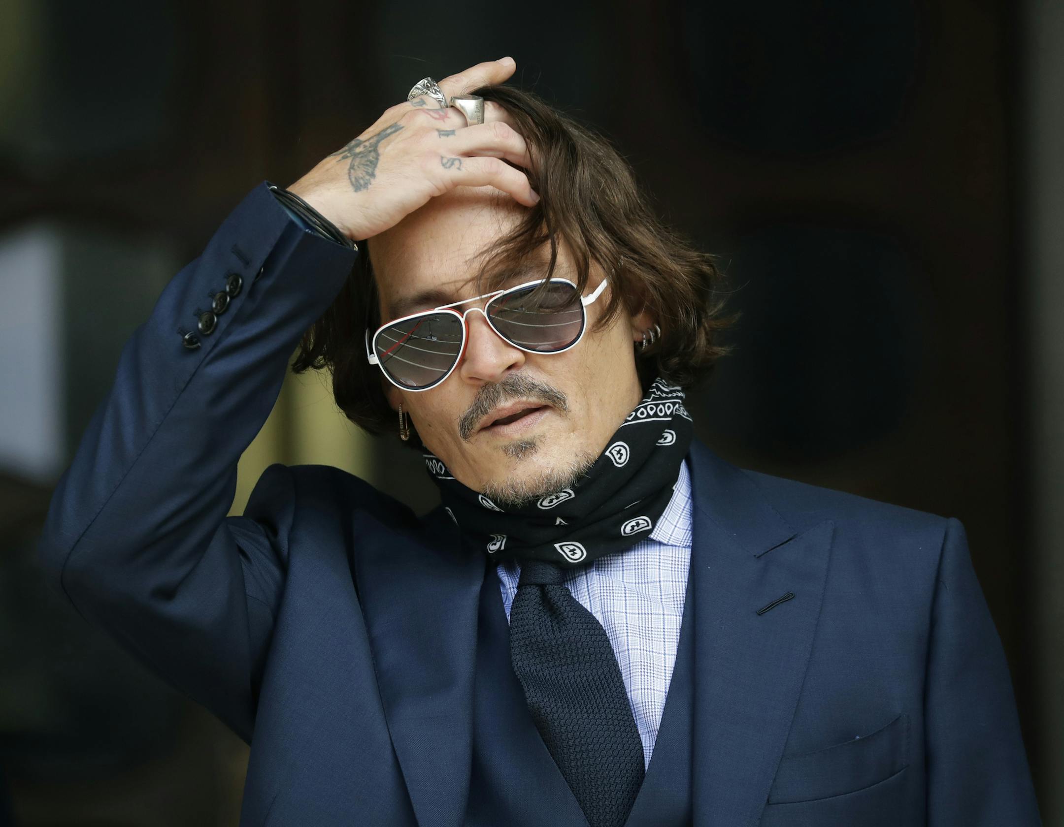 FILE - In this Tuesday, July 14, 2020 file photo, American actor Johnny Depp gestures to the media as he arrives at the High Court in London. The UK High Court has ruled against Johnny Depp in his libel suit against the owner of the Sun newpaper over wife-beating allegation, it was reported on Monday, Nov. 2, 2020. (AP Photo/Matt Dunham, file)