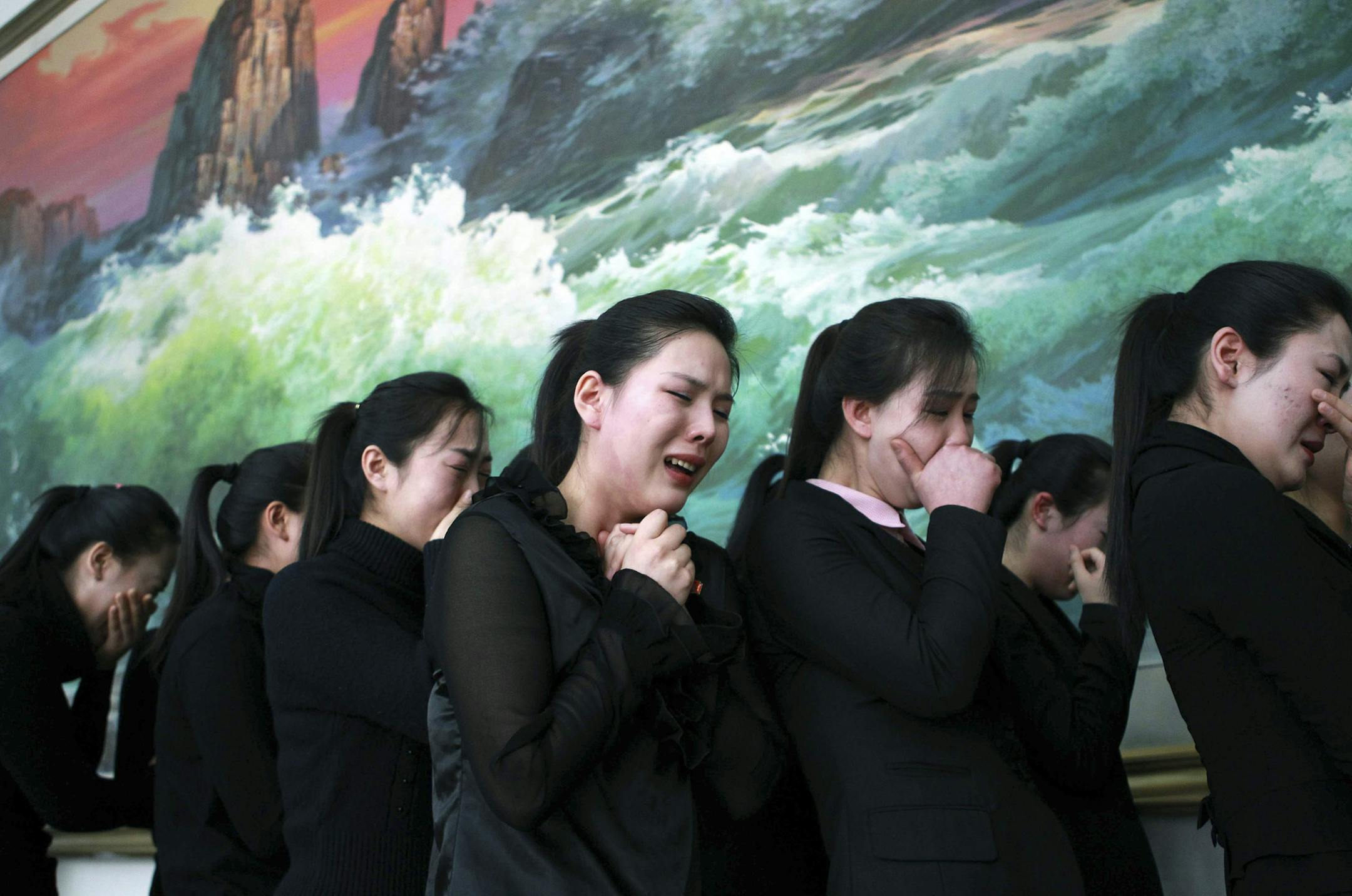 In this photo released by China's Xinhua news agency, North Koreans living in China mourn the death of their leader Kim Jong Il at North Korean Embassy in Beijing, China, Tuesday, Dec. 20, 2011. (AP Photo/Xinhua, Liu Weibing) NO SALES