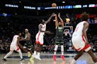 Timberwolves center Karl-Anthony Towns hits a 3-pointer under pressure by Rockets forward Usman Garuba during the second quarter