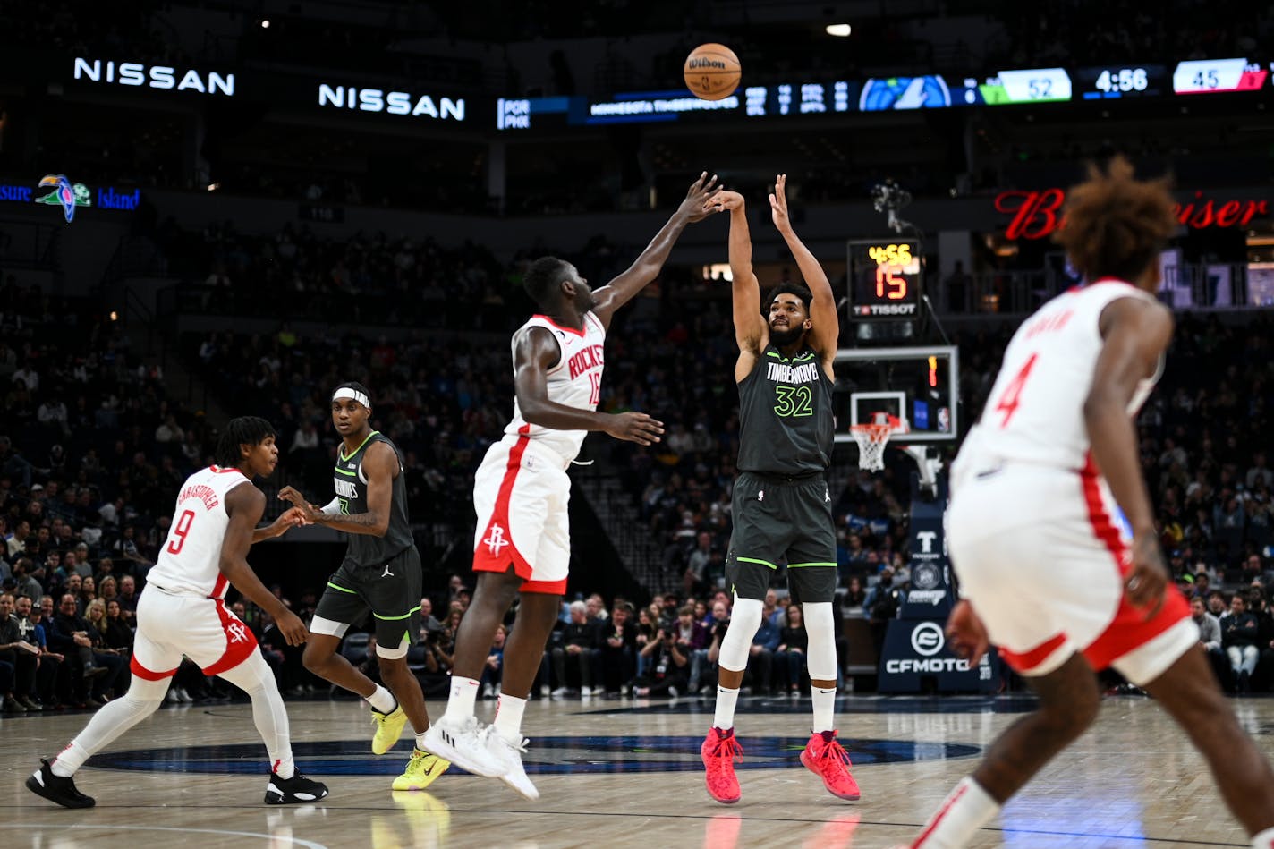 Timberwolves center Karl-Anthony Towns hits a 3-pointer under pressure by Rockets forward Usman Garuba during the second quarter