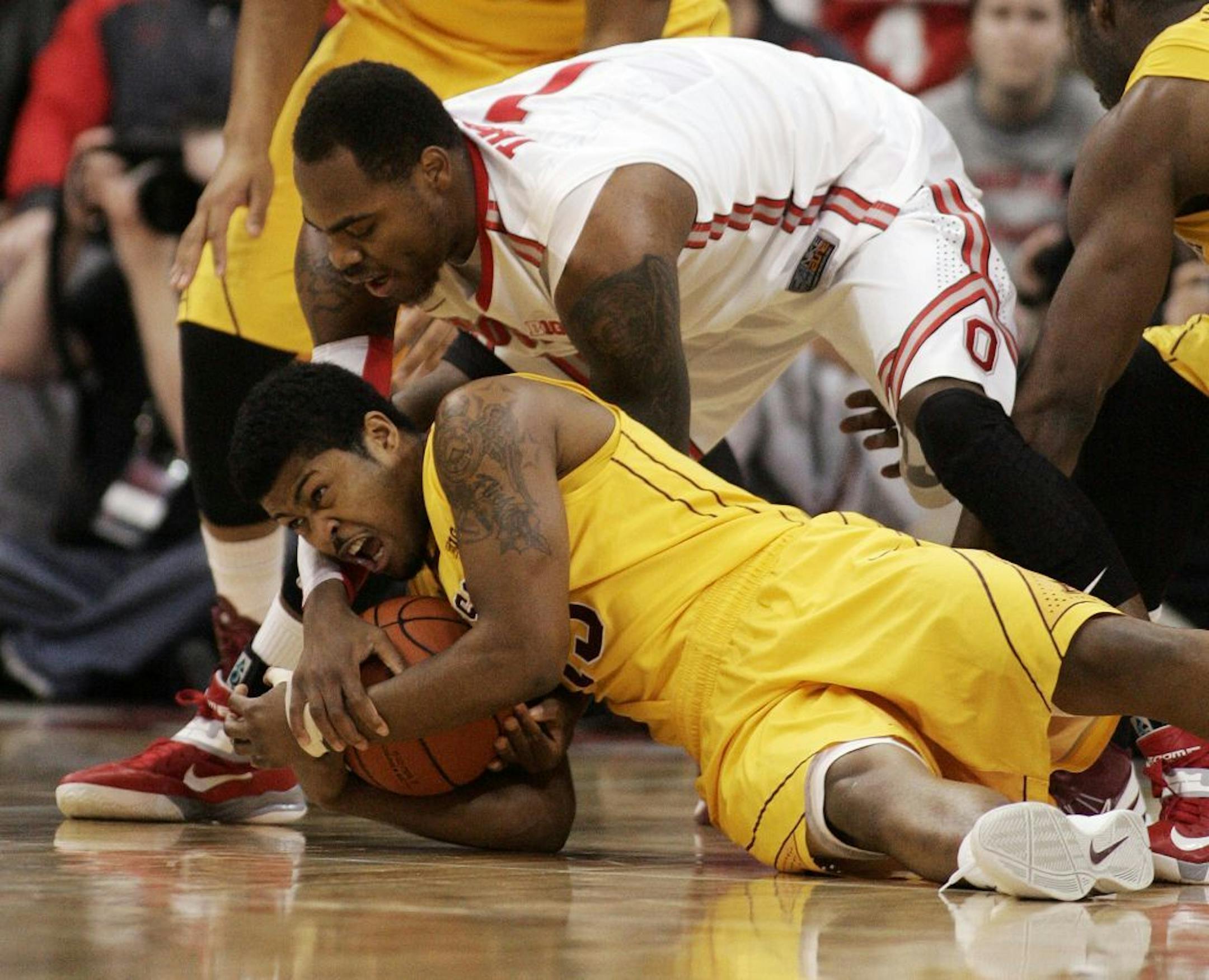 Ohio State's Deshaun Thomas, top, fights for the ball with Minnesota's Maverick Ahanmisi.