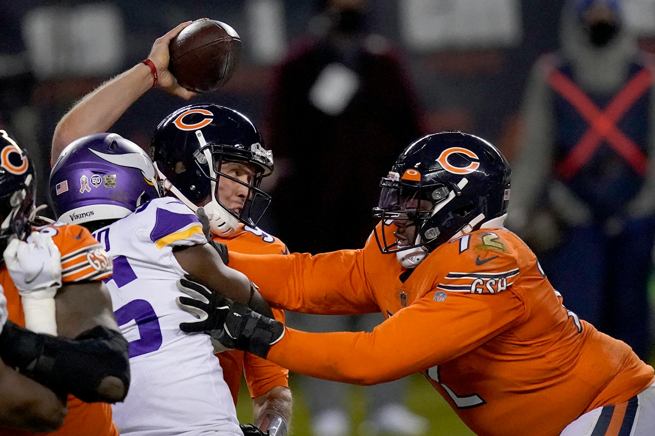 Chicago Bears quarterback Nick Foles tries to throw under pressure from Minnesota Vikings defensive end Ifeadi Odenigbo, left, as Bears offensive tackle Charles Leno Jr., right, pushes Odenigbo during the second half of an NFL football game Monday, Nov. 16, 2020, in Chicago. Foles was injured on the play and left the game. (AP Photo/Charles Rex Arbogast)