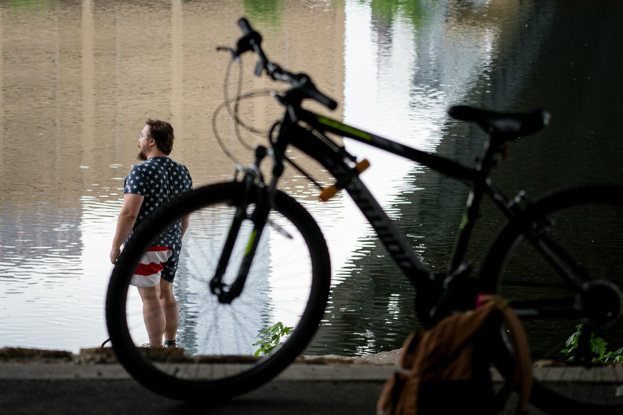 A bicyclist clad in flag-themed clothes looks out at the Mississippi river before the annual Freedom From Pants Ride in Minneapolis.