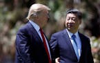 FILE - In this April 7, 2017 file photo, President Donald Trump, left, and Chinese President Xi Jinping walk together after their meetings at Mar-a-La
