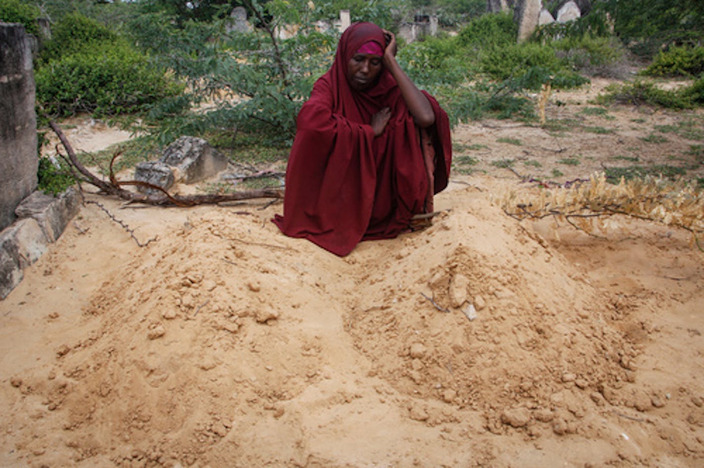 FILE - Fatuma Abdi Aliyow sits by the graves of her two sons who died of malnutrition-related diseases last week, at a camp for the displaced on the outskirts of Mogadishu, Somalia, Sept. 3, 2022. Millions of people in the Horn of Africa region are going hungry because of drought, and thousands have died, with Somalia especially hard hit. (AP Photo/Farah Abdi Warsameh, File)