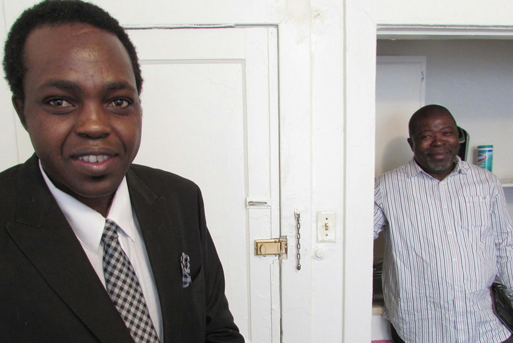 Warcheerah Kilima, left, and "rapid rehousing" coordinator Mosudi Idowu in Kilima's Trenton apartment. Before getting the partment, Kilima said he was sleeping in a train station while working nights as a mail sorter. (Tim Henderson/Stateline/TNS) ORG XMIT: 1168217