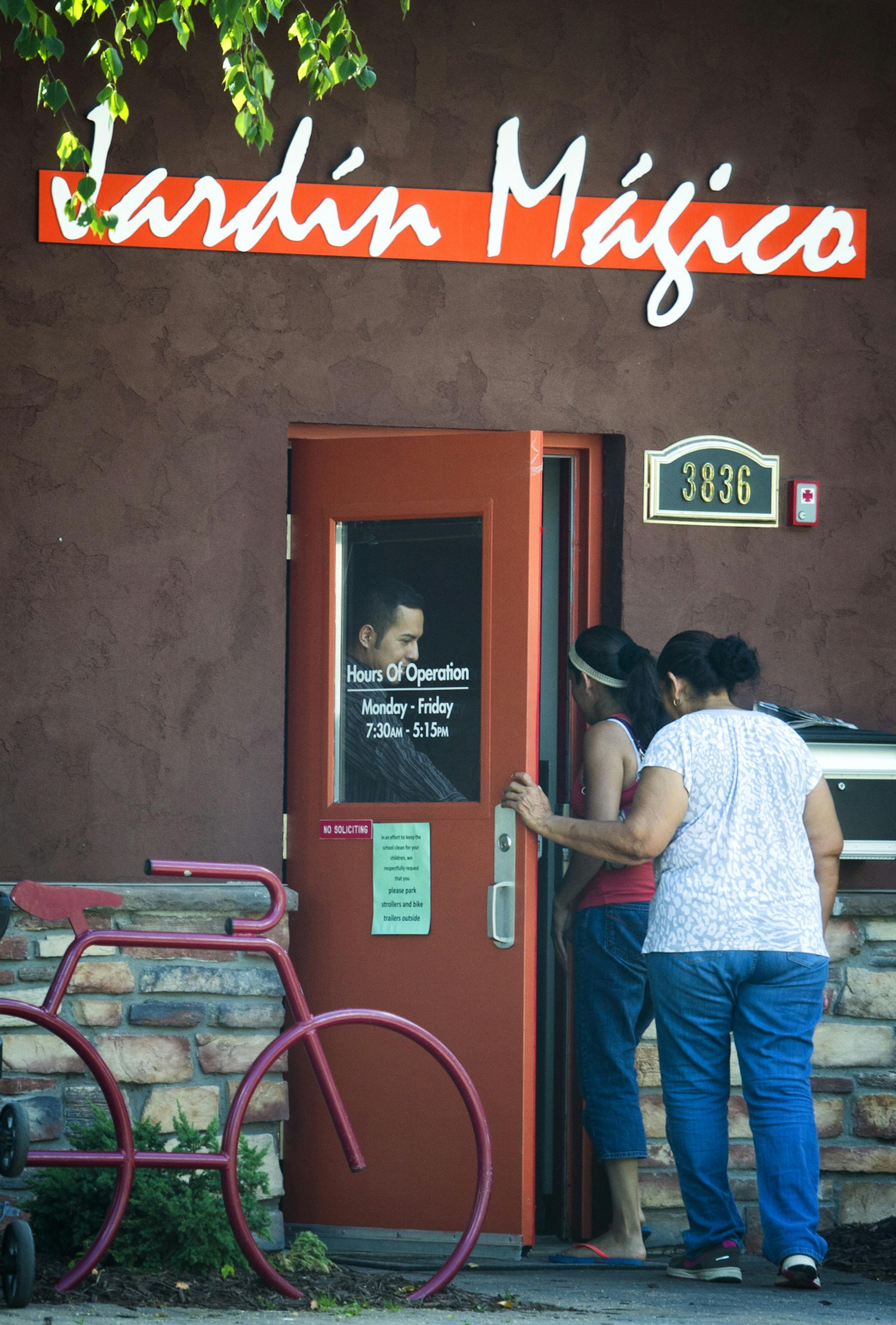 A worker opened the front door for two adults at Jardin Magico Spanish immersion daycare and preschool on Minnehaha Avenue, Minneapolis. Tuesday, July 16, 2013 ] GLEN STUBBE * gstubbe@startribune.com
