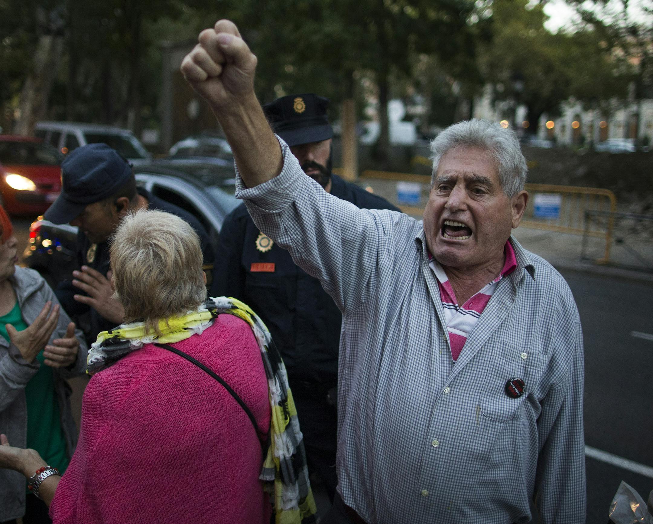 Police clear the street as dozens of protestors shout slogans calling for the resignation of Spain's Health Minister Ana Mato, in front of the Health Ministry building in Madrid, Spain, Tuesday, Oct. 7, 2014. Three more people were placed under quarantine for Ebola at a Madrid hospital where a Spanish nurse became infected, authorities said Thursday. More than 50 other possible contacts were being monitored. The nurse, who had cared for a Spanish priest who died of Ebola, was the first case of E