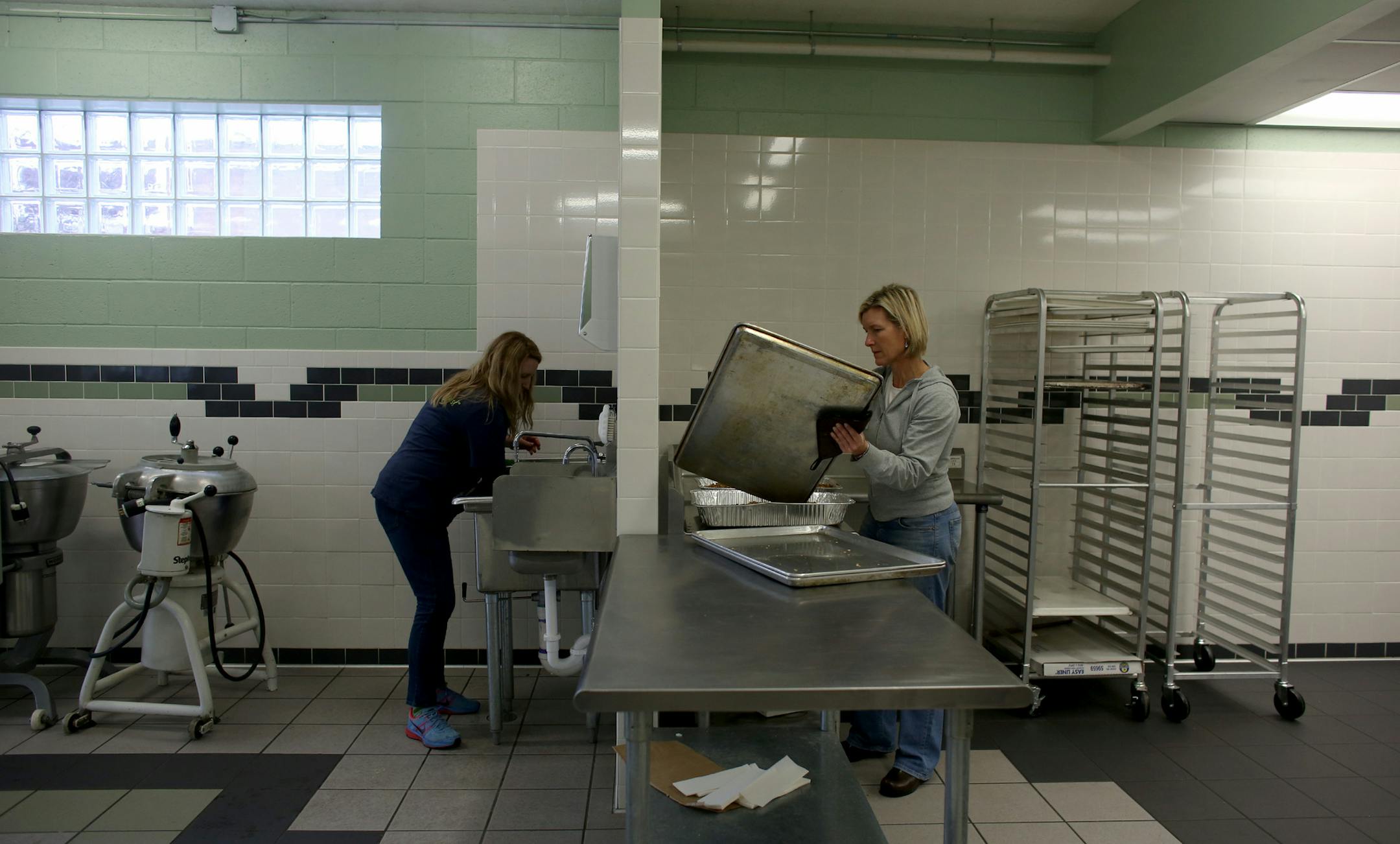 Jen Thorpe, of Green Bee Juicery, washed fennel on the left as Patti Heimbold, of Patti's Granola, wiped off trays from toasting granola. ] (KYNDELL HARKNESS/STAR TRIBUNE) kyndell.harkness@startribune.com At City Food Studio in Minneapolis, Min., Tuesday, December 9, 2014.