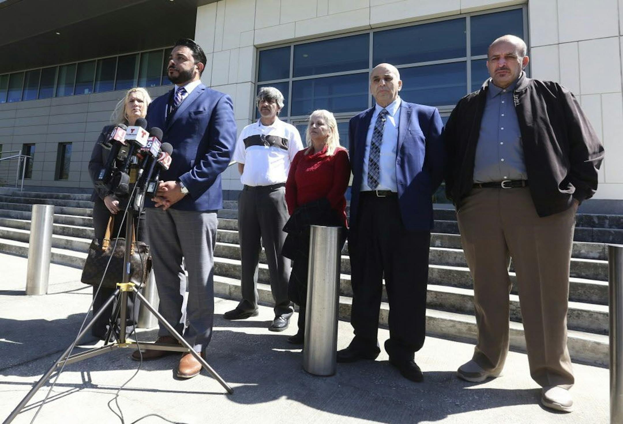 Susan Clary, spokesperson for Noor Salman's family, Ahmed Bedier, President, United Voices For America, 2nd from left, and the four members of Noor Salman's family, right, address the media Wednesday, March 14, 2018, outside the Federal courthouse in Orlando, Fla.