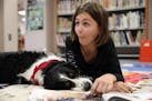 Layla Larsen, 9, a fourth grader at Sioux Trail Elementary School laughed as she read with therapy dog Arthur, a 5-year-old English Springer Spaniel, 