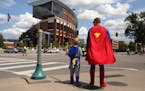 Minnesota United season ticket holders Josh Thompson and his son Franklin, 5, of Robbinsdale, Minn. waited to cross the street dressed as Batman and S