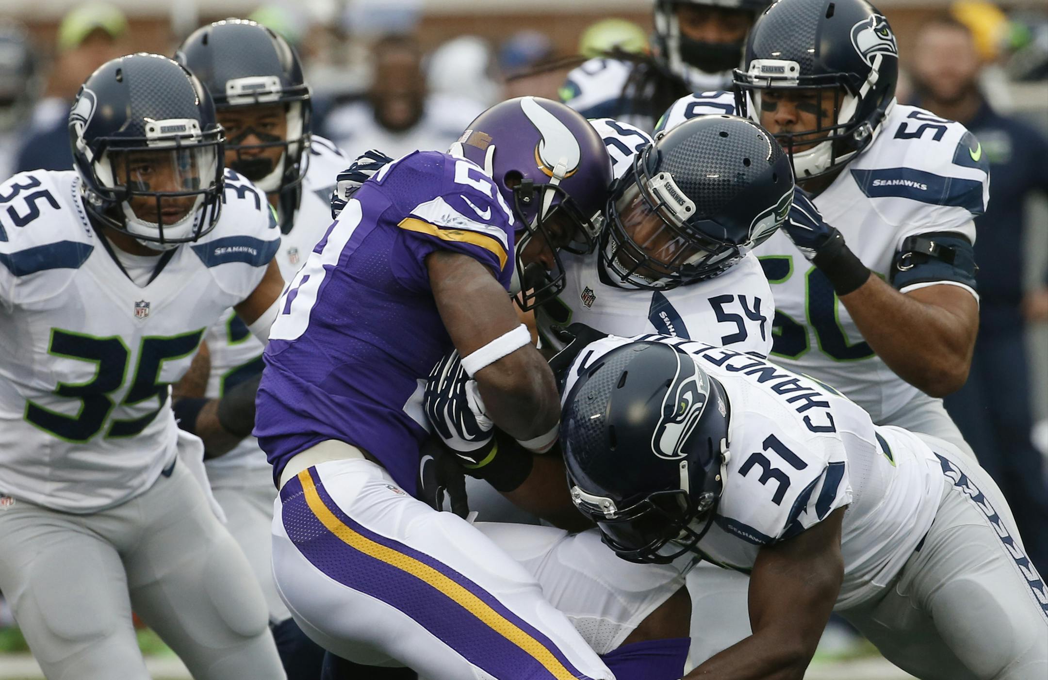 FILE - In this Dec. 6, 2015, file photo, Minnesota Vikings running back Adrian Peterson (28) is stopped by Seattle Seahawks defenders including linebacker Bobby Wagner (54) and strong safety Kam Chancellor (31)in the first half of an NFL football game in Minneapolis. The Cardinals play the battered Minnesota Vikings on Thursday in Arizona. (AP Photo/Ann Heisenfelt, File)