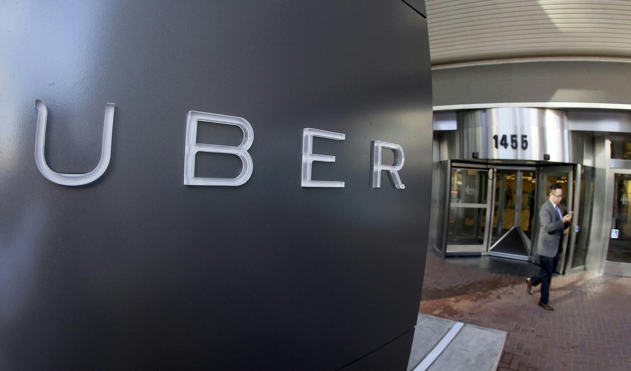 FILE - In this Dec. 16, 2014, file photo a man leaves the headquarters of Uber in San Francisco. Uber and Volvo announced, Thursday, Aug. 17, 2016, a $300 million deal for Volvo to provide SUVs to Uber for autonomous vehicle research. Eventually the Volvo SUVs will be part of the self-driving fleet in Pittsburgh.(AP Photo/Eric Risberg, File) ORG XMIT: NY107