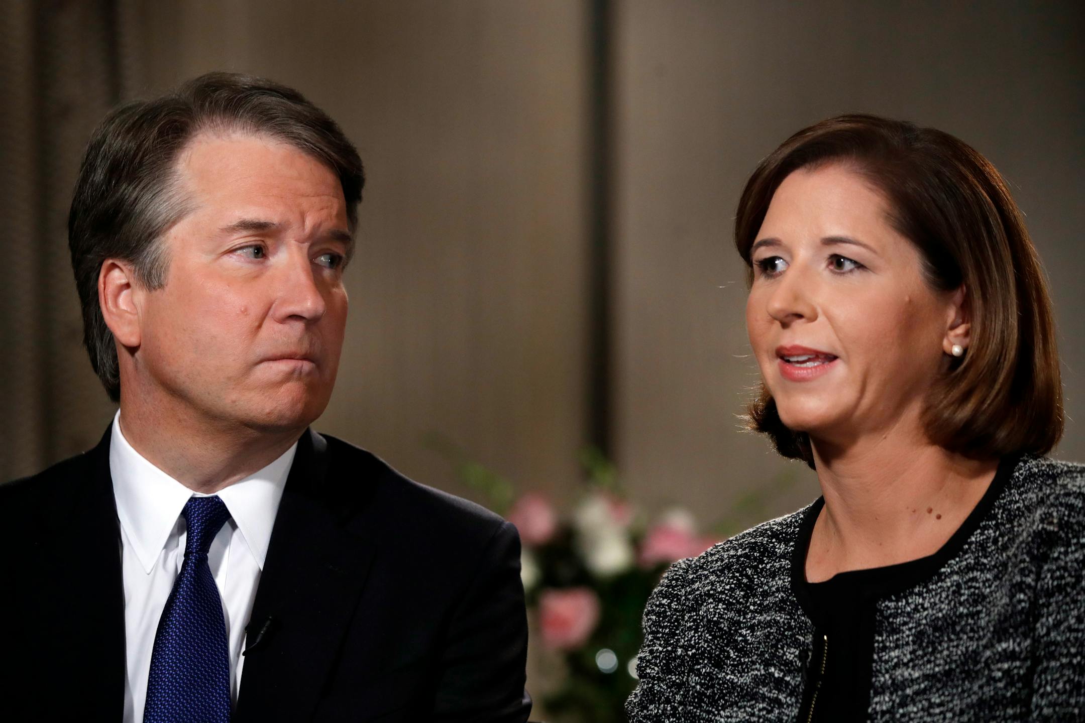Brett Kavanaugh, left, looks at his wife Ashley Estes Kavanaugh as they answer questions during a FOX News interview, Monday, Sept. 24, 2018, in Washington, about allegations of sexual misconduct against the Supreme Court nominee. (AP Photo/Jacquelyn Martin)