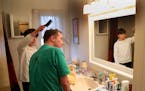 On a day Bob White, 47, who has A.L.S., volunteers at the school of his son, Kieran, 13, washes his father�s hair in the shower before brushing Bob�