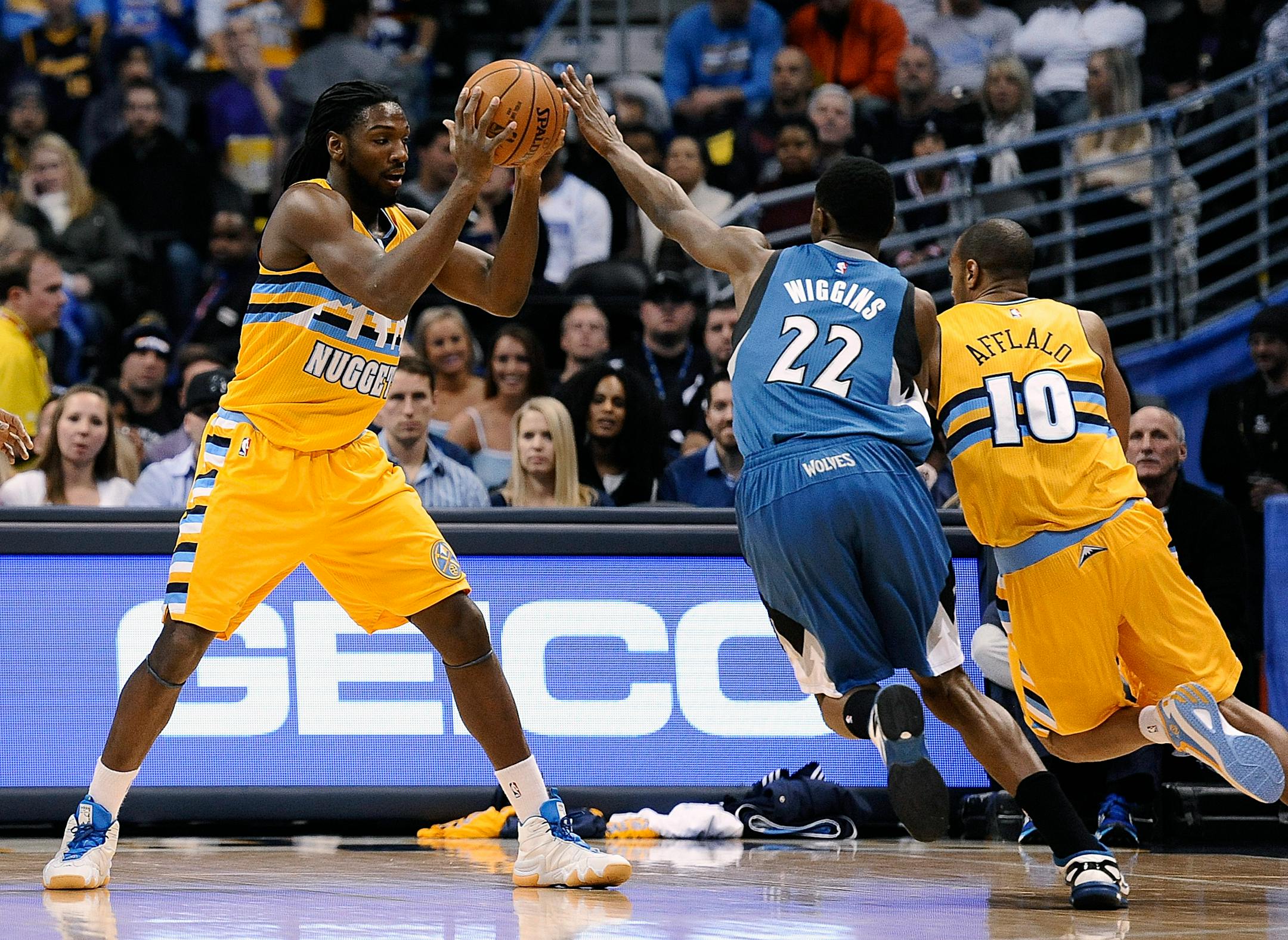 Nuggets forward Kenneth Faried looked to pass to guard Arron Afflalo (10) while Timberwolves forward Andrew Wiggins defended during the first half Friday.