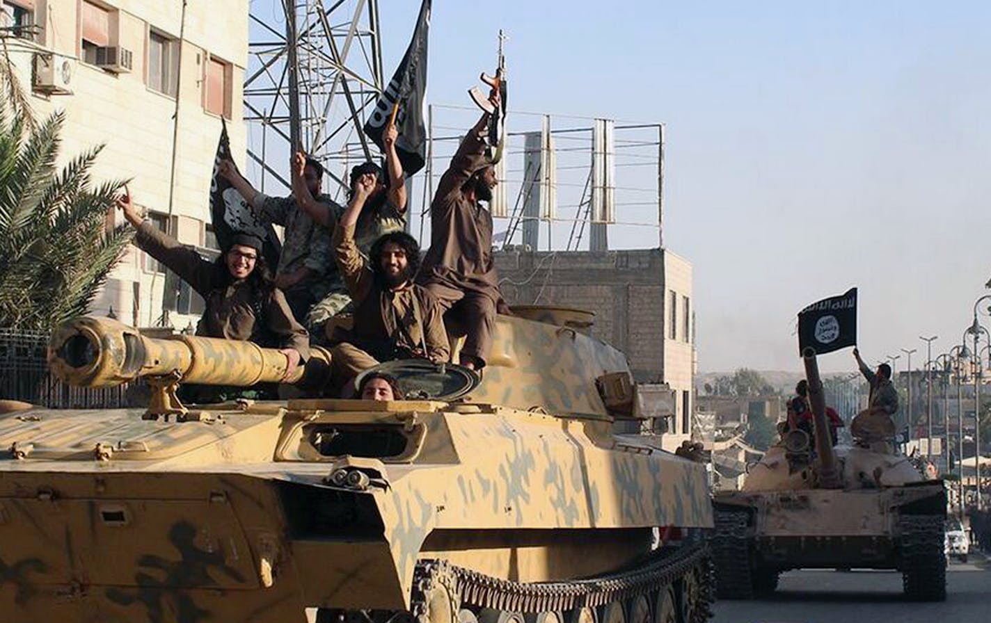 FILE- This undated image posted by the Raqqa Media Center, a Syrian opposition group, on Monday, June 30, 2014, which has been verified and is consistent with other AP reporting, shows fighters from the al-Qaida linked Islamic State group during a parade in Raqqa, Syria. The Gulf nation of Qatar is hitting back at suggestions that it supports the Islamic State extremist group, saying that �determined, collective action� is needed to end sectarian violence gripping Iraq and Syria. Qatari Foreign