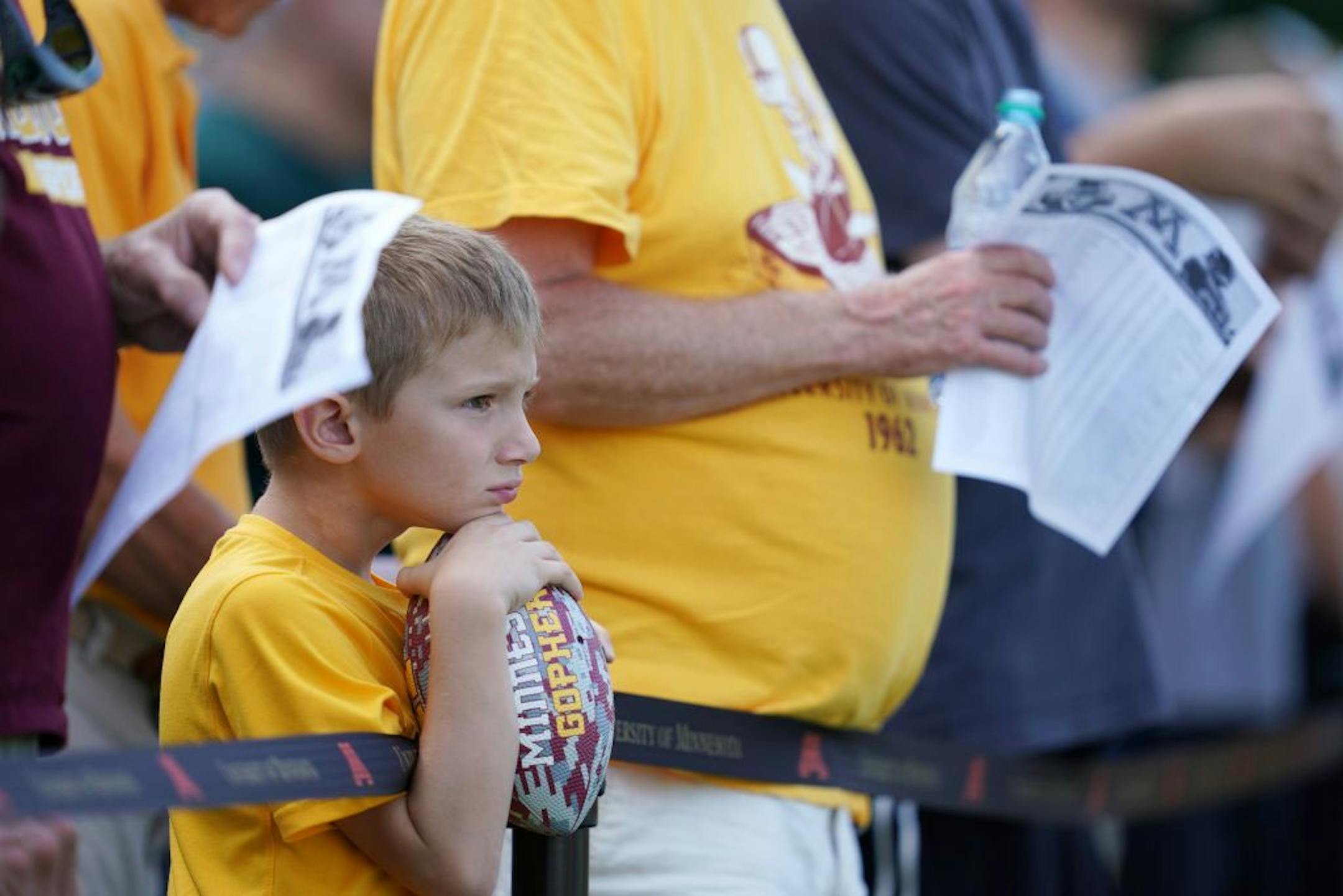 Louis Roeller, 7, watched with football in hand as the Golden Gophers held an open practice Friday afternoon.