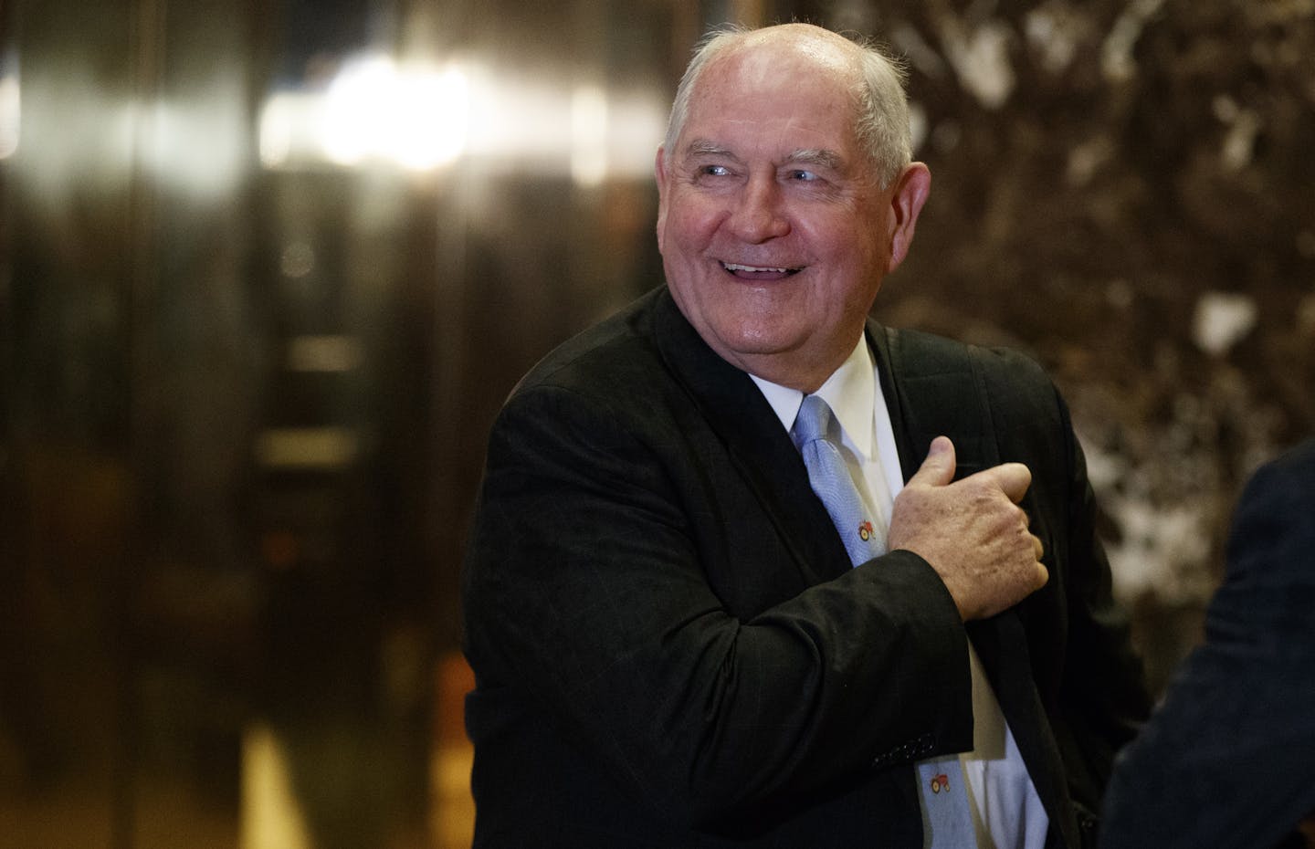 FILE- In this Nov. 30, 2016, file photo, former Georgia Gov. Sonny Perdue smiles as he waits for an elevator in the lobby of Trump Tower in New York. A person familiar with the decision says President-elect Donald Trump has chosen Perdue to serve as agriculture secretary. (AP Photo/Evan Vucci, File)