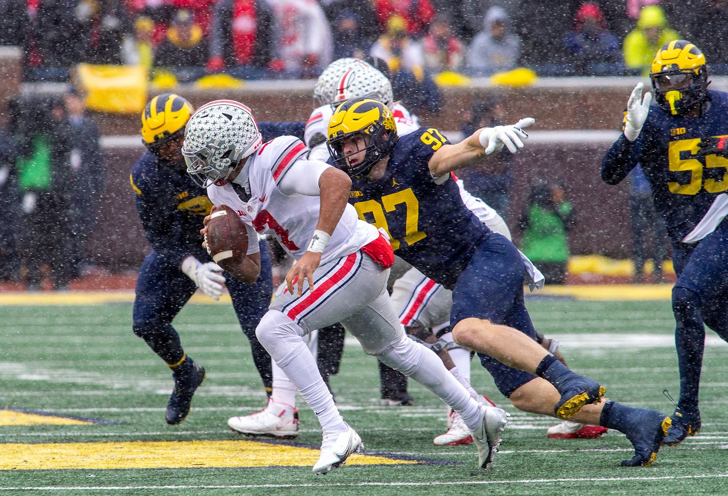 Ohio State quarterback C.J. Stroud (7) scrambles away from Michigan defensive end Aidan Hutchinson (97) in the second quarter of an NCAA college football game in Ann Arbor, Mich., Saturday, Nov. 27, 2021. (AP Photo/Tony Ding)