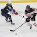 Canada's Brianne Jenner (19) works the puck against United States' Kelly Pannek (12) during the first period of a women's exhibition hockey game ahead