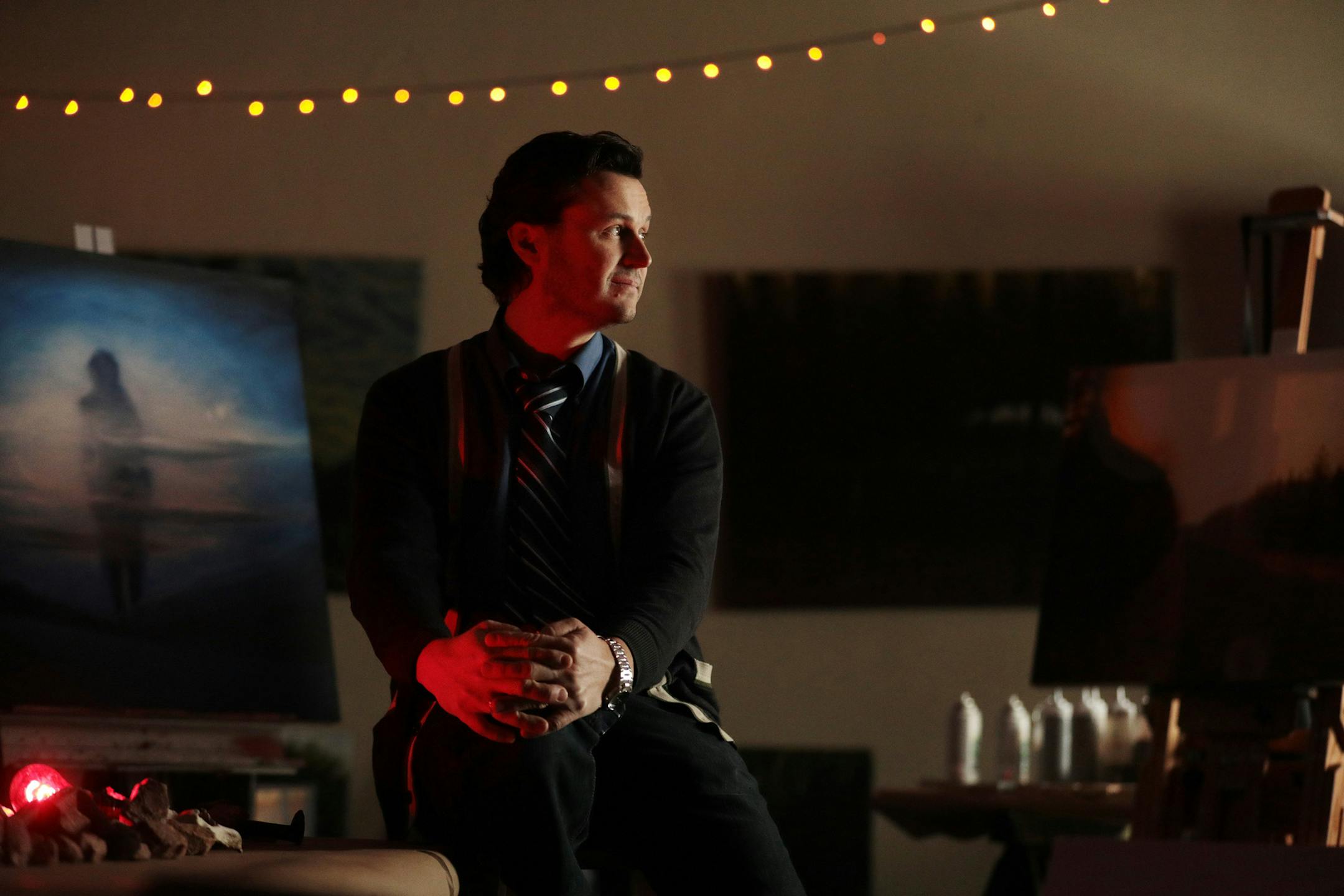 Artist Brandon Kuehn, who travels the state of Minnesota visiting sites of paranormal activity and then making art inspired by it, sits for a portrait at his studio.