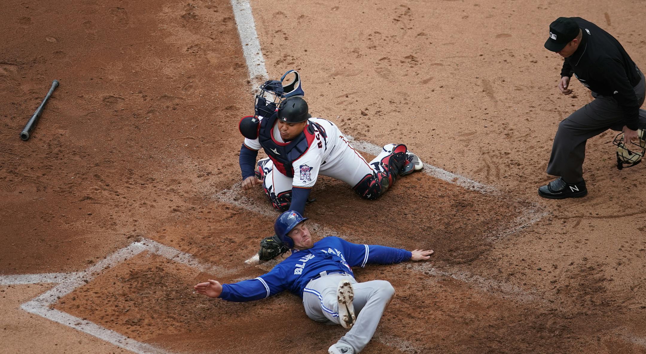 Toronto's Billy McKinney was safe at home after Twins catcher Willians Astudillo missed the tag in the fourth inning at Target Field