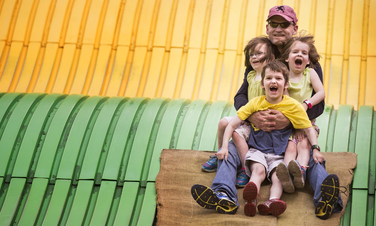 Dan Huse of Woodbury rides the giant slide with his son Calvin, 6, and twin four-year-old daughters Hana, left, and Lexi at the Minnesota State Fair on Friday, August 28, 2015.