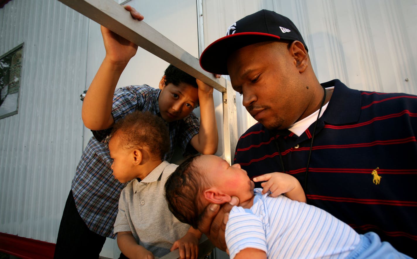 Chaka Mkali, aka I Self Devine, held Kahlil as Ash, 10, and Ezrah, 2, looked on.