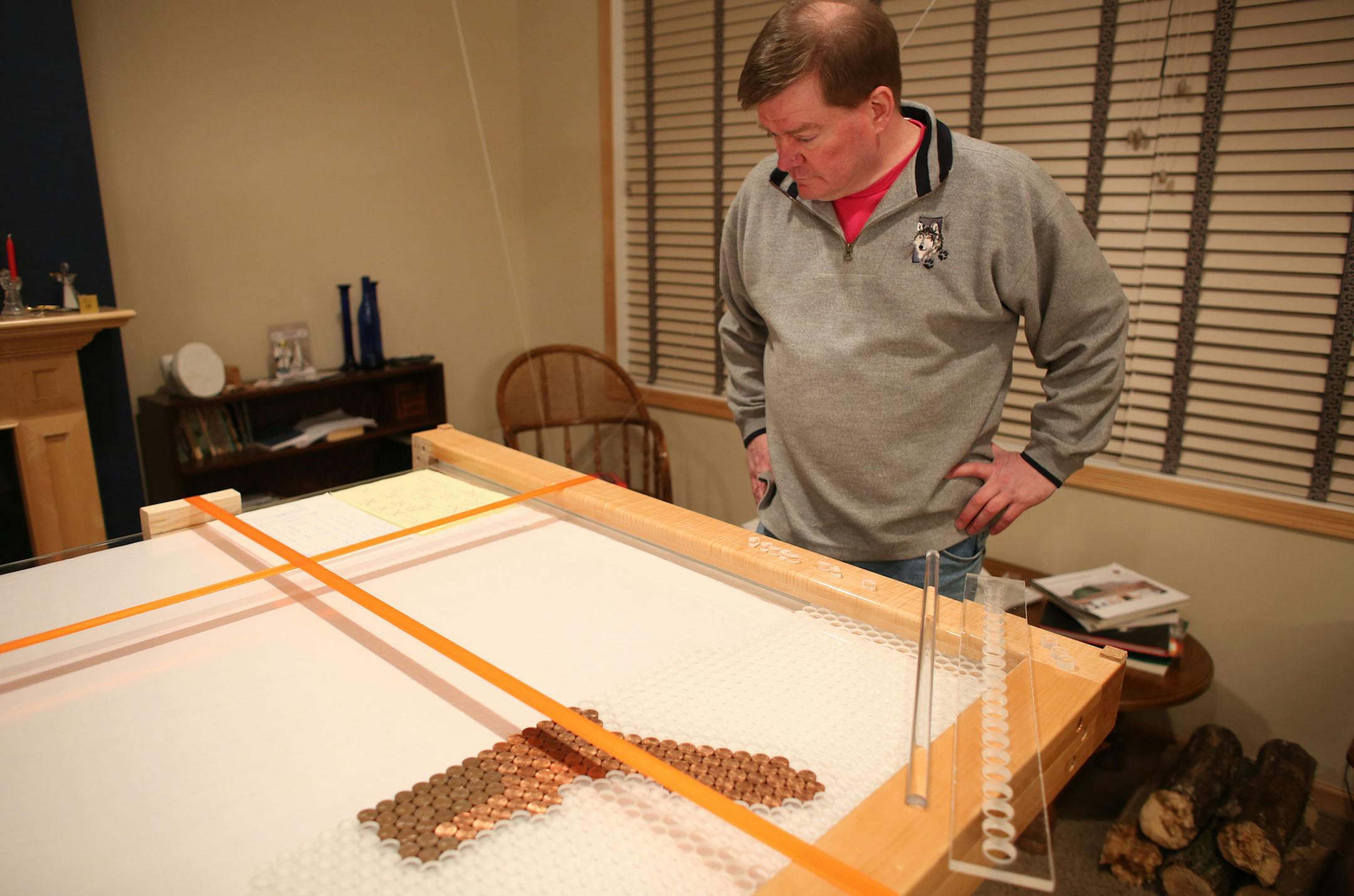 John Ebert explained his process as he looked over the start to his map of pennies ] (KYNDELL HARKNESS/STAR TRIBUNE) kyndell.harkness@startribune.com At the home of John Ebert in Brooklyn Park Tuesday, March 4 2014.