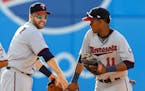 The Twins' Brian Dozier, left, and Jorge Polanco (11) celebrate after the Twins defeated the Cleveland Indians 4-2 on Saturday.