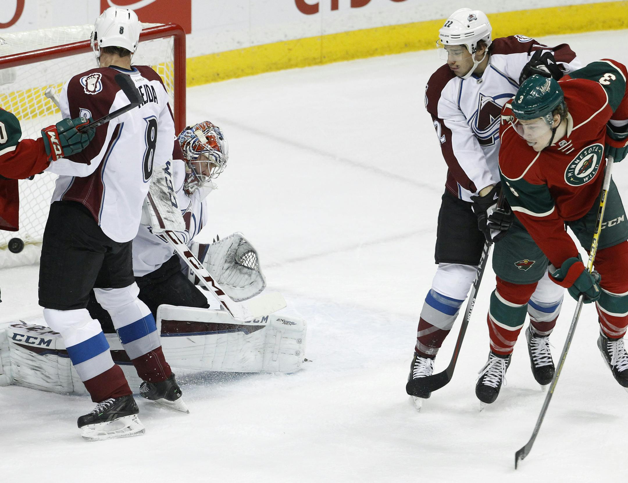 Minnesota Wild center Charlie Coyle (3) scores against Colorado Avalanche goalie Semyon Varlamov, second from left, of Russia, as Avalanche defenseman Zach Redmond (22) watches during the first period of an NHL hockey game in St. Paul, Minn., Saturday, Feb. 7, 2015. (AP Photo/Ann Heisenfelt)