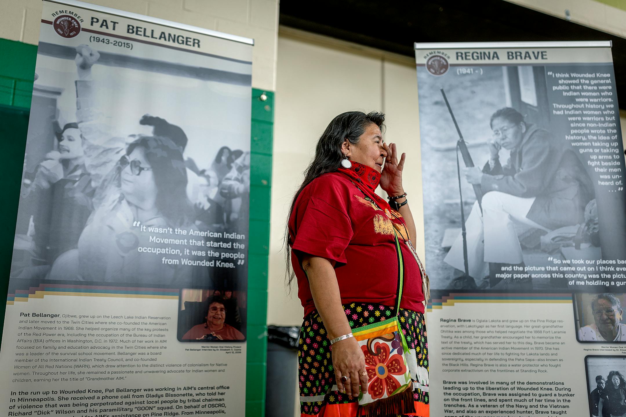 American Indian Movement Minnesota director Lisa Bellanger becomes emotional as she talks to people visiting the exhibit honoring the Women of Wounded Knee, including her mother Pat Bellanger, (in photo behind her) in Porcupine, SD on the Pine Ridge Indian Reservation.