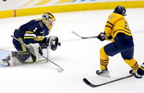 Michigan goalie Erik Portillo (1) blocks a shot by Collin Graf (11) of Quinnipiac in the second period Thursday, April 6, 2023, at Amalie Arena in Tam